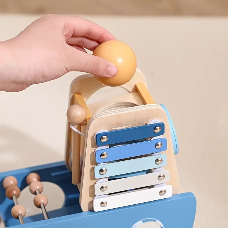 Wooden toy with beads and a hand interacting with it on a neutral background