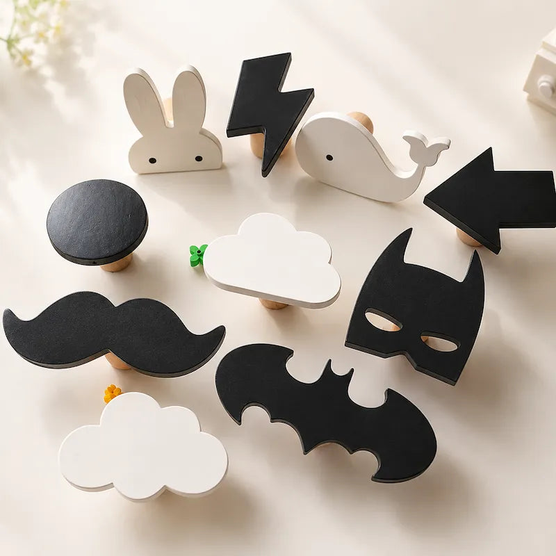 A set of wooden children's toy signs with rounded edges, featuring shapes like a rabbit, whale, lightning bolt, arrows, mustache, cloud, bat, and a small green leaf, arranged on a light cream surface.