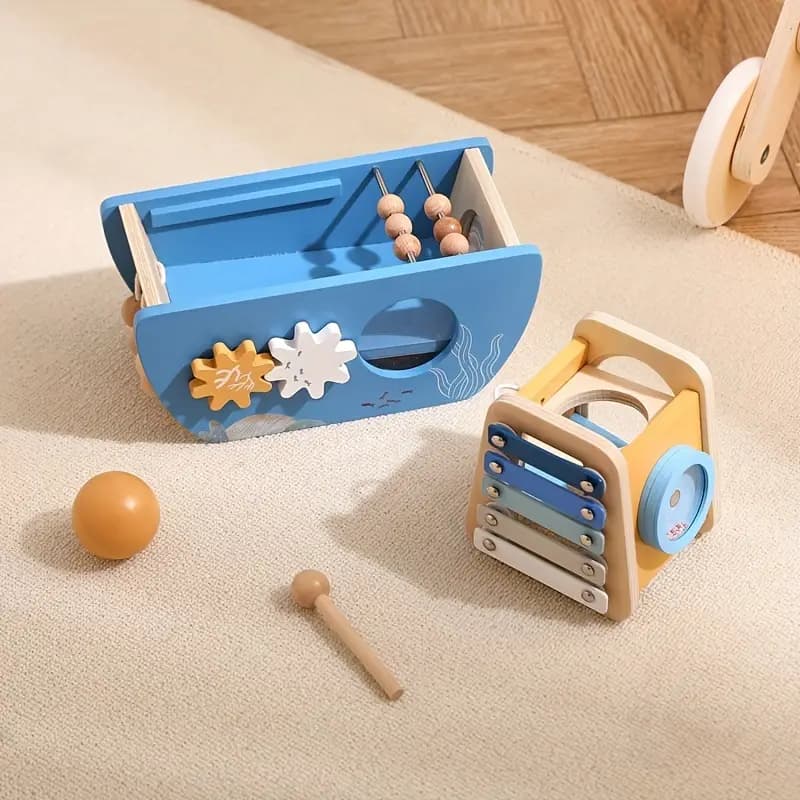 Wooden toy set with blue toolbox and colorful xylophone on a beige surface.