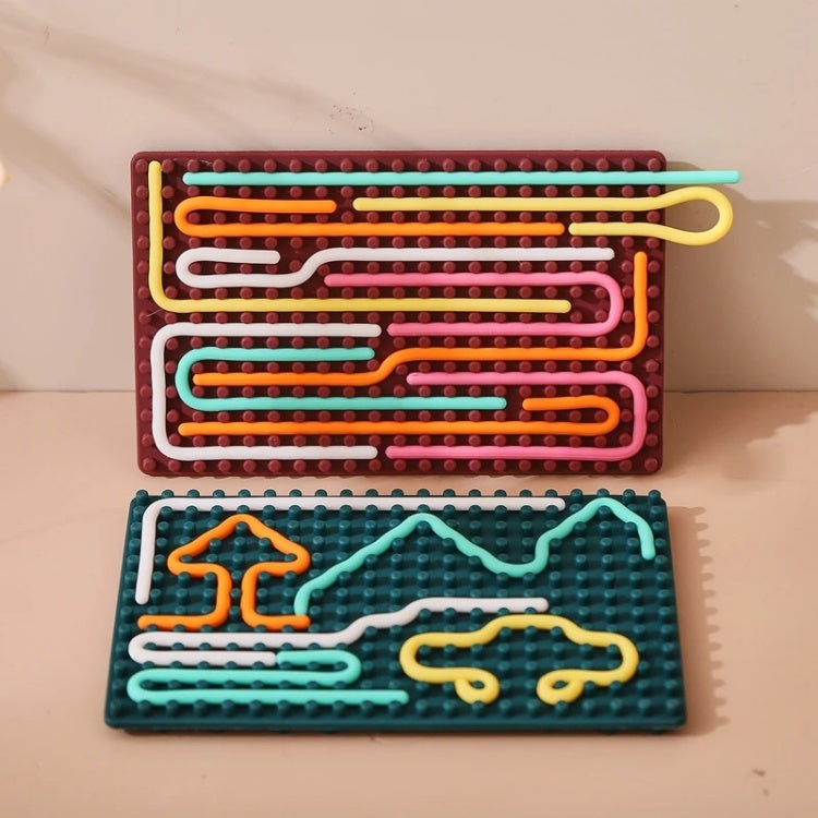 Two colorful maze boards made of interlocking bricks on a beige surface.