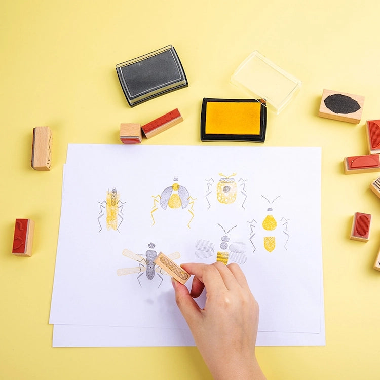 Hand stamping illustrations of insects on a piece of paper with various stamps and ink pads | Wooden Bug Stamp Art Set