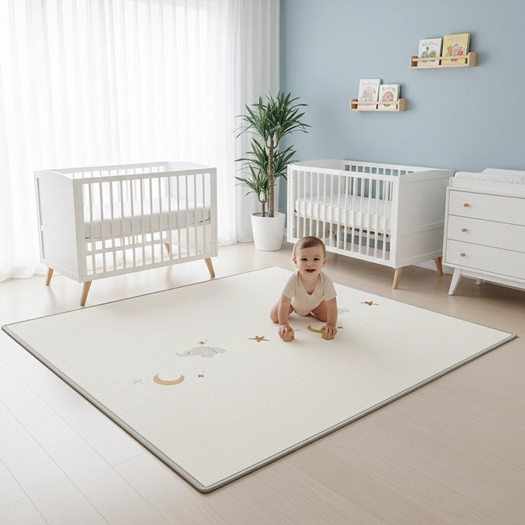 Baby playing on a mat in a room with white cribs and a blue wall.