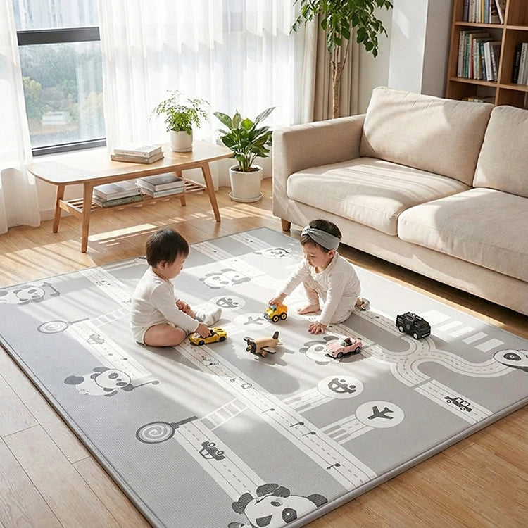 Two children playing on a large play mat with road designs in a living room.