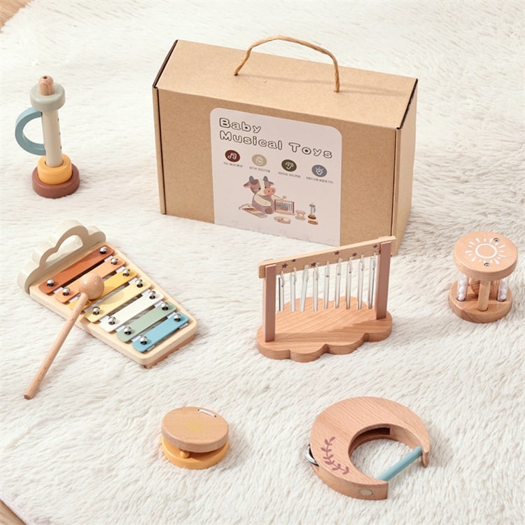 Set of baby musical toys with a cardboard box labeled 'Baby Musical Toys' on a white blanket.