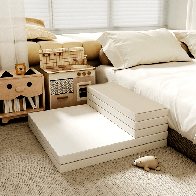 Children's play area with toy kitchen set and foam mats on a carpeted floor.