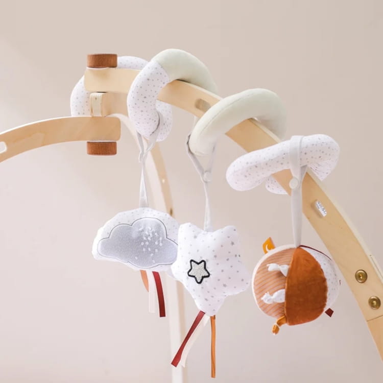 Baby mobile with cloud, star, and sun shapes hanging from a wooden stand.