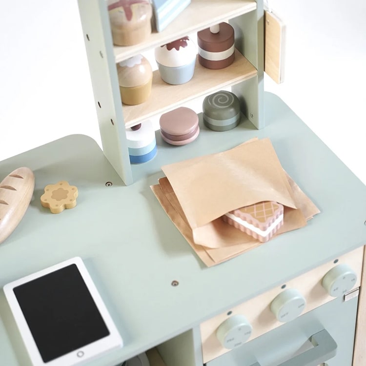 Children's play kitchen set with shelves, table, and tablet on a light background