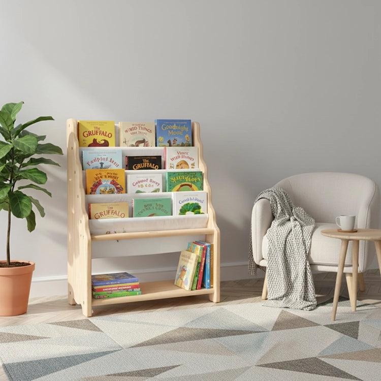 Wooden bookshelf with children's books in a room with a chair and plant.